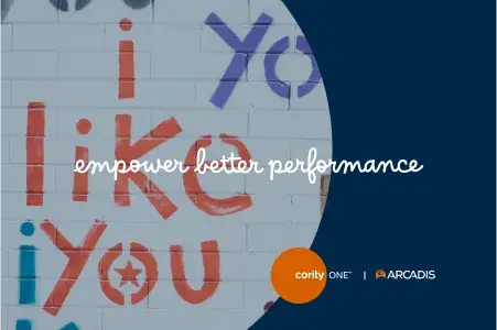 Un mur avec un texte coloré indiquant i like you en rouge et bleu, surmonté de la phrase empower better performance en écriture cursive blanche. Les logos de Cority One et d'Arcadis se trouvent dans le coin inférieur droit.