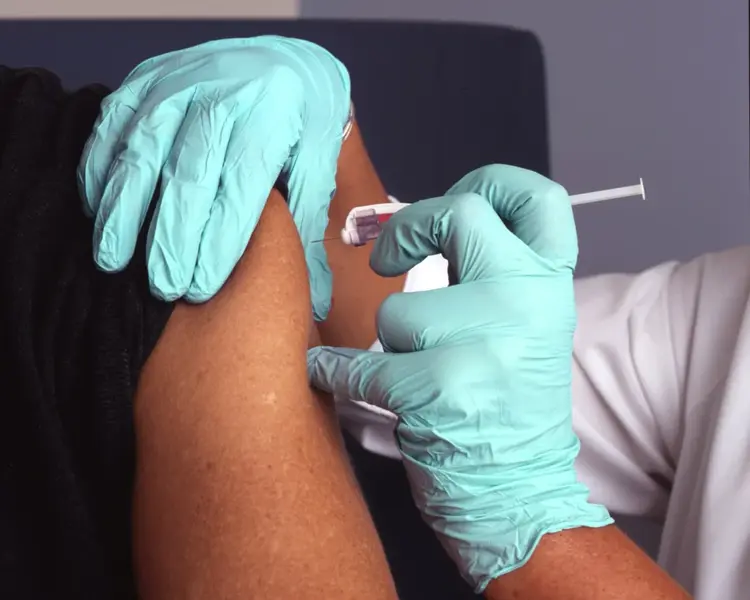 Occupational health flu vaccination injected into workplace employee